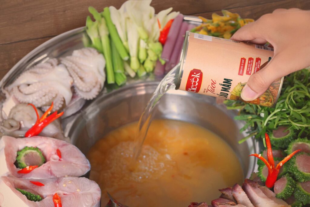 Rót gia vị lẩu mắm Cicook vào nồi lẩu
